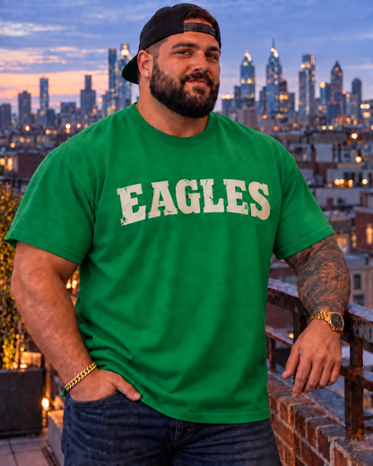 Man wearing a Kelly green Eagles T-shirt overlooking the Philadelphia skyline