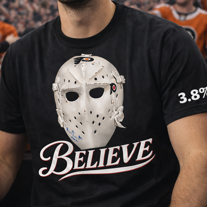Person wearing a black t-shirt with a hockey goalie mask graphic and 'BELIEVE' text.